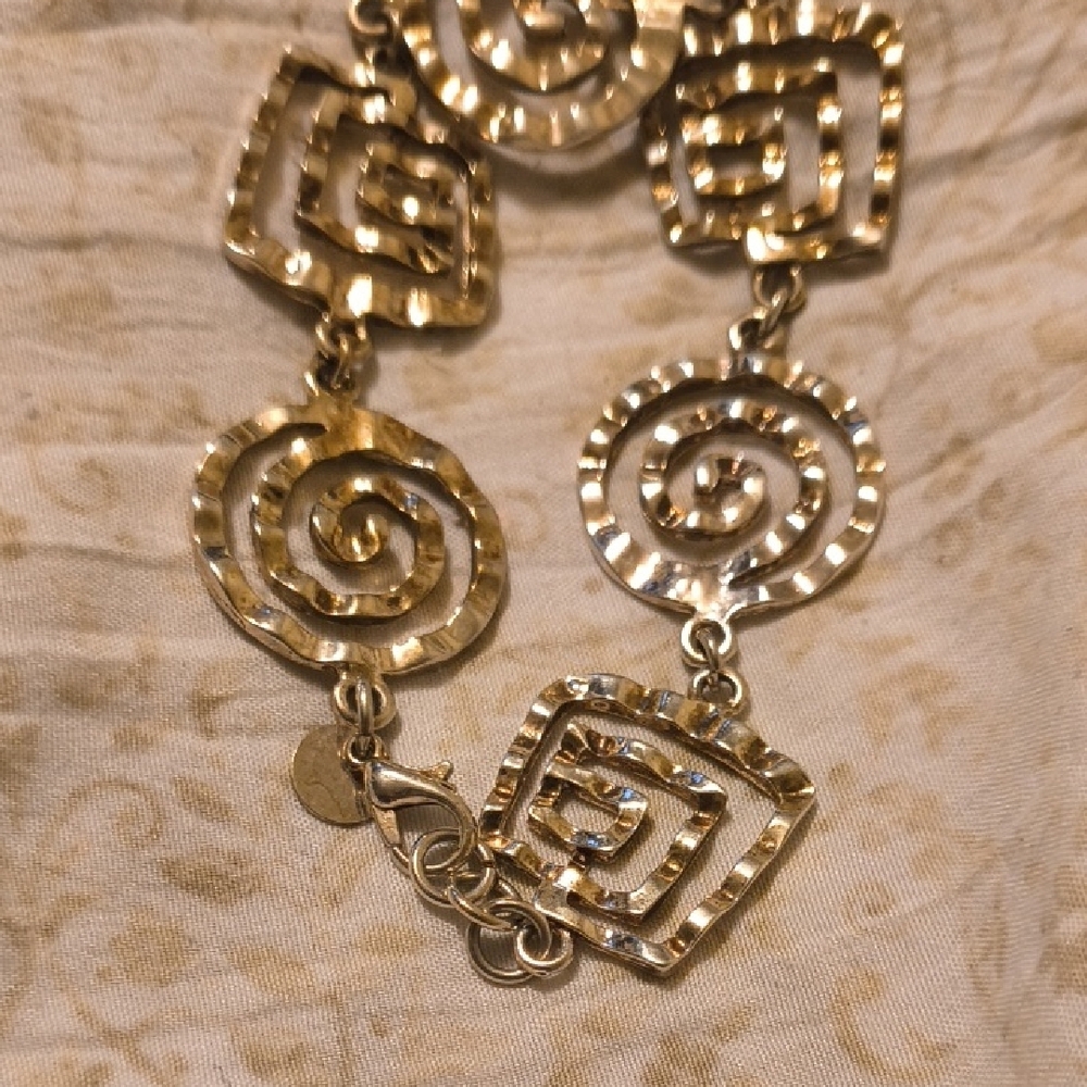 Artistic Gold Spiral Bracelet with Geometric Charms